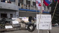 A man takes a "selfie" with a mobile phone at a barricade in front of the seized SBU state security service in Luhansk, in eastern Ukraine