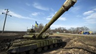 Cars pass a tank position close to the Russian border near the Ukrainian city of Kharkiv